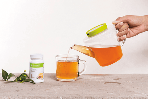 Té Verde sabor Granada  Polvo para preparar té instantaneo siendo servido en un vaso.